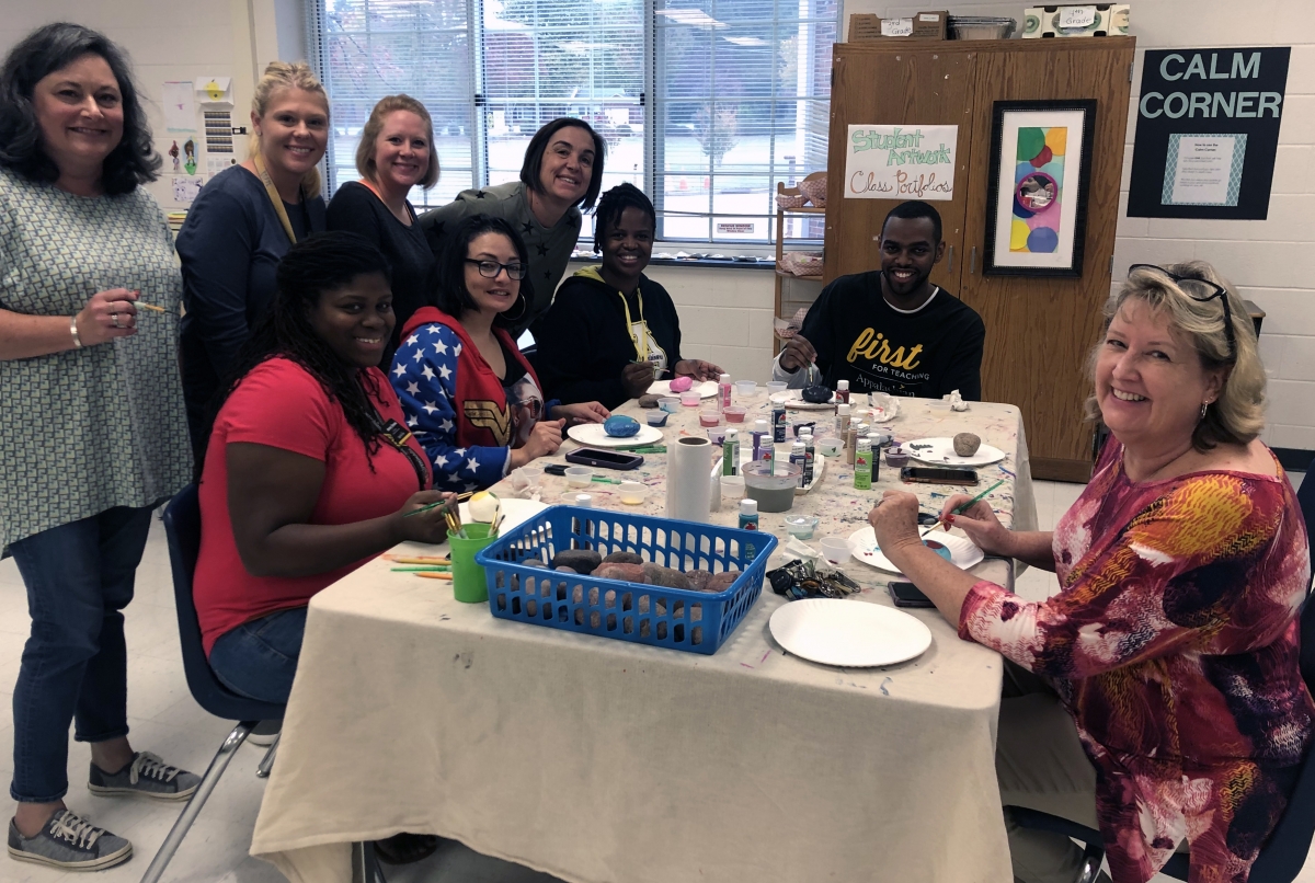 Academy teachers and staff paint their identity rocks. Photo submitted