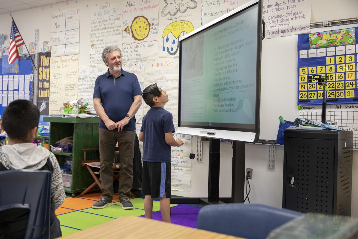 Academy third grader, Angel Torres Alexander, underlines his favorite part of the poem as Rice observes. Photo by Troy Tuttle