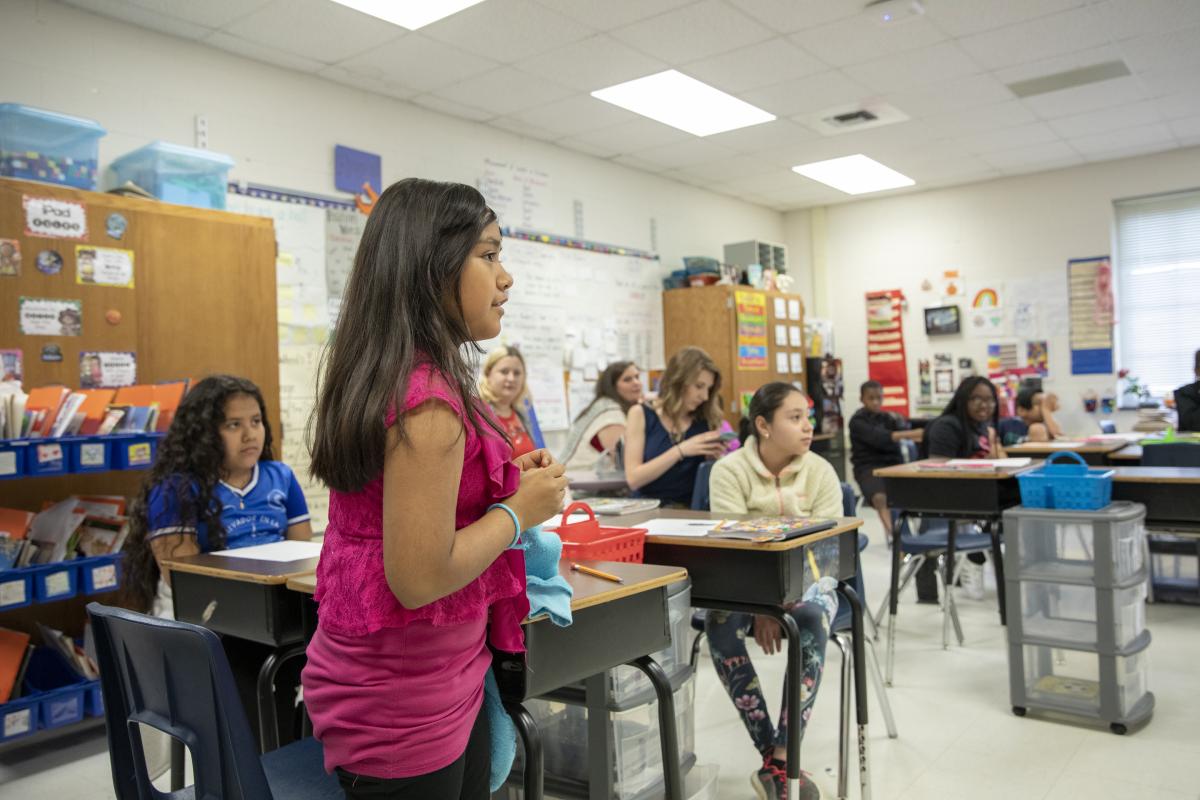 Academy third grader, Itzel Escobar-Torres, shares the first line of her poem. Photo by Troy Tuttle