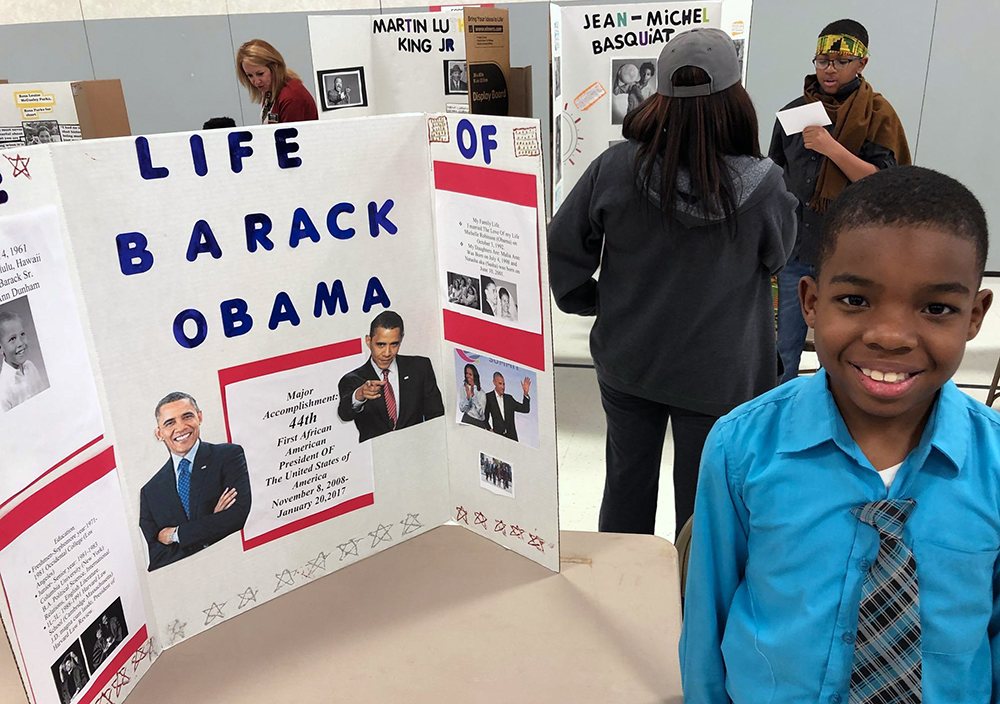 Ray'Jon Davis-McCullen, 4th grade student at the Academy, stands beside his Wax Museum project on President Barack Obama.