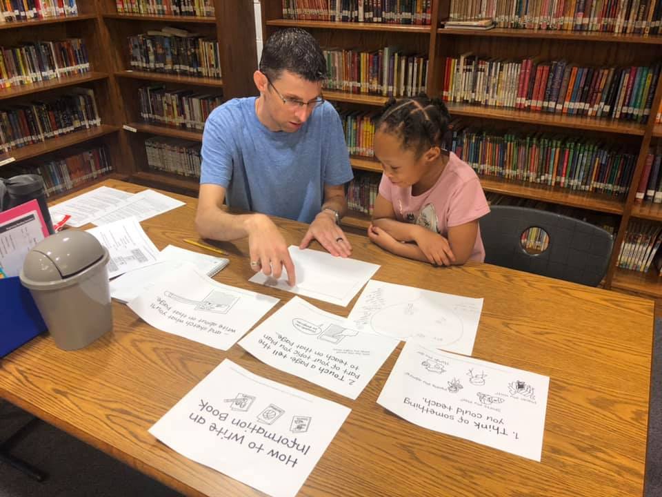 Macrow (left) and rising 1st grader Alicia Spain (right) work on writing nonfiction at the Academy’s summer reading clinic. Photo by Amie Snow