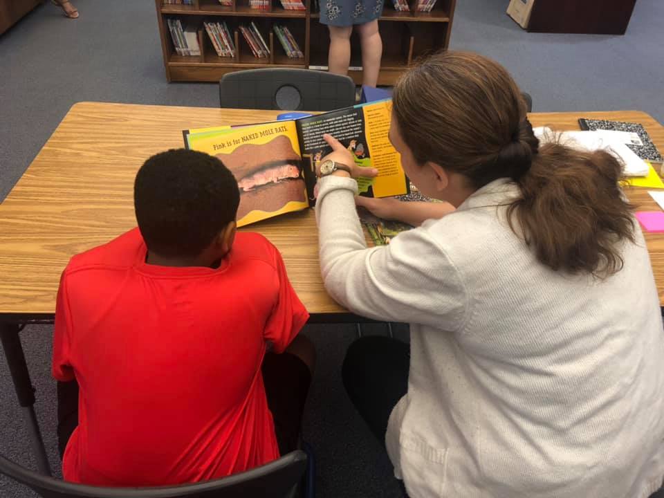 Rising 5th grade Tracen Tyner (left) and reading education graduate student Kim Settlemyre (right) read together at the Academy’s summer reading clinic. Photo by Amie Snow