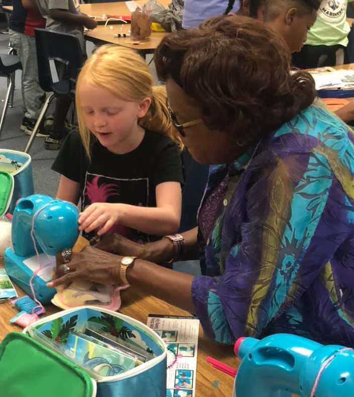 4th grade teacher Wanda McLemore (right) teaches rising 3rd grader Quinlan Hushbeck (left) how to use a sewing machine as part of the Academy’s summer enrichment program. Photo by Amie Snow