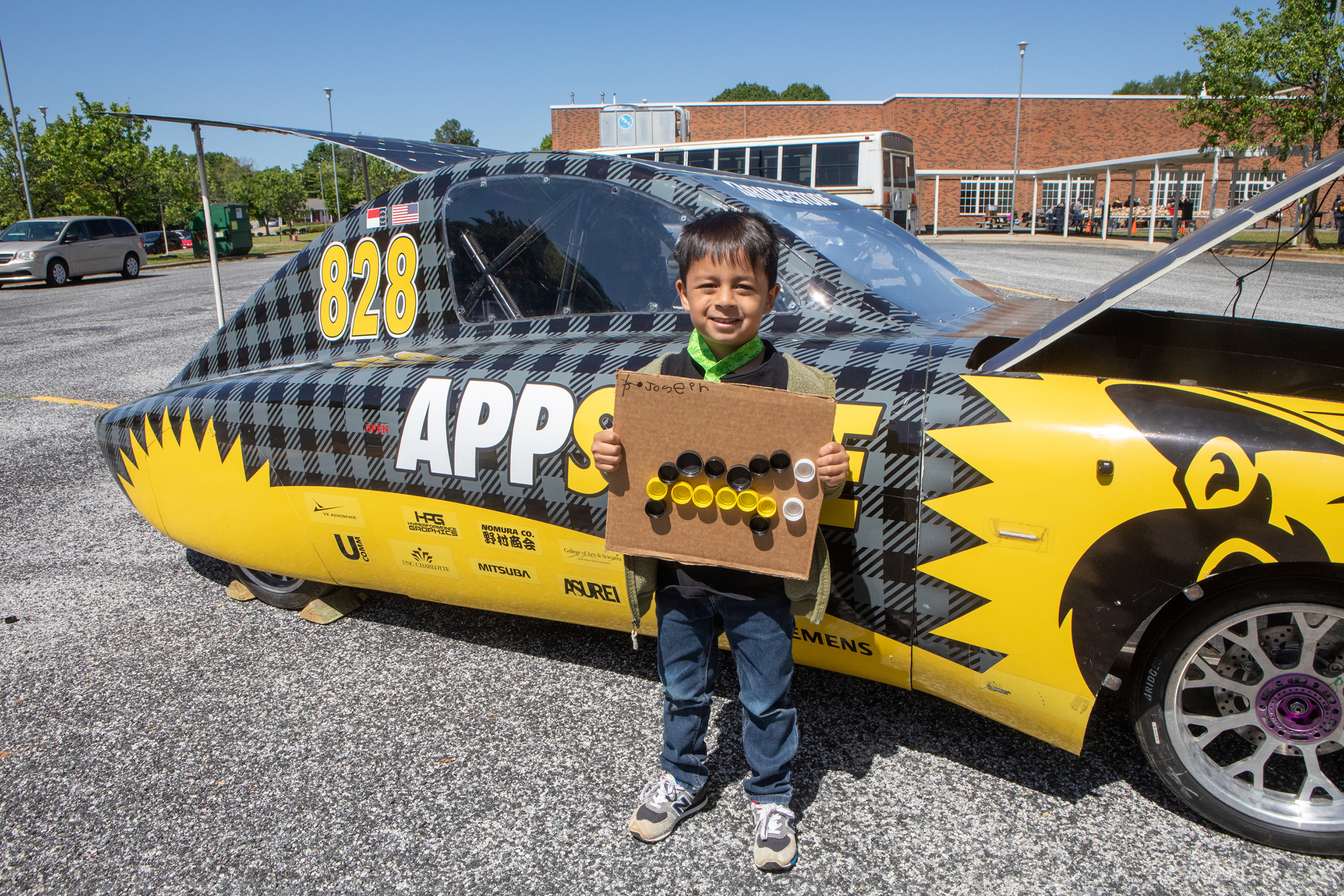 Boy standing in front of solar vehicle Boy standing in front of solar vehicle